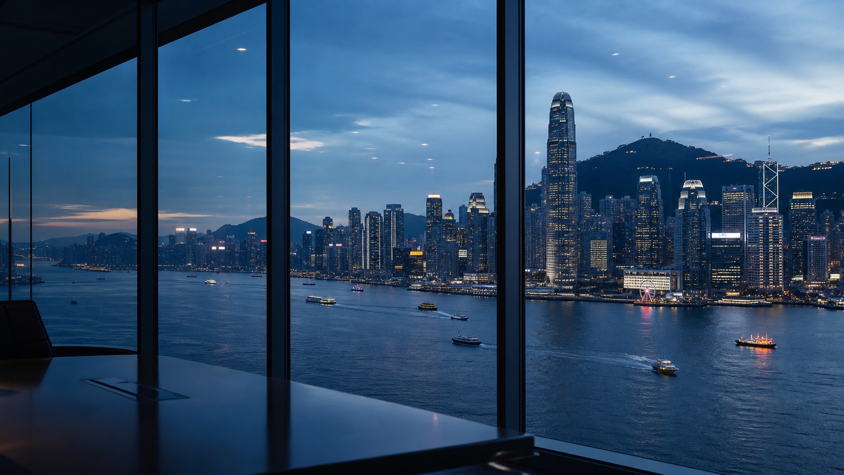 Victoria Harbour and Hong Kong's business district viewed from a boardroom at blue hour